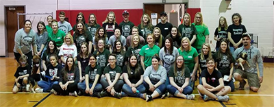 Staff and students pose in a gym