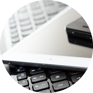 a laptop, tablet and phone stacked on top of each other