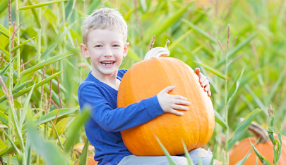 Child holding pumpkin