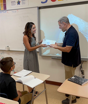 Female administrator presenting grant to teacher