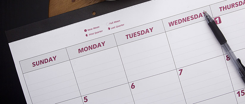 Calendar with a pen on top of it
