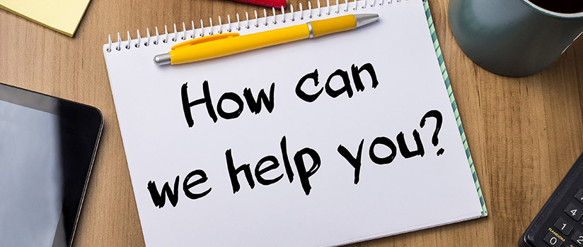 Notebook with a pen on top and the text how can we help you?